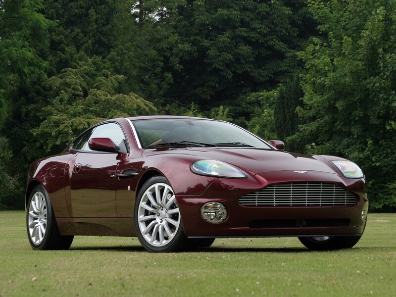 maroon aston martin on grass