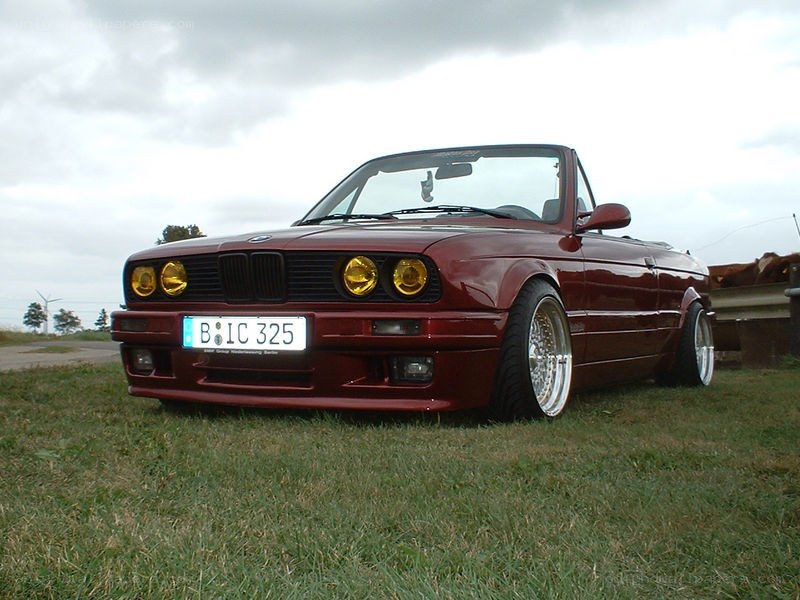 Maroon BMW convertible on grass