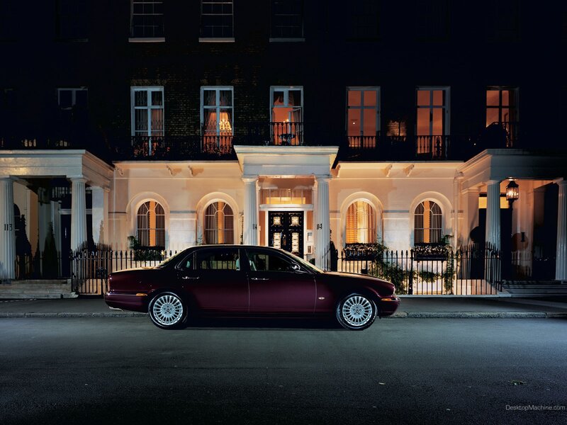 Maroon car at night in front of building