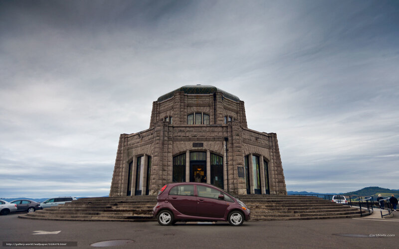 Maroon car in front of stone building