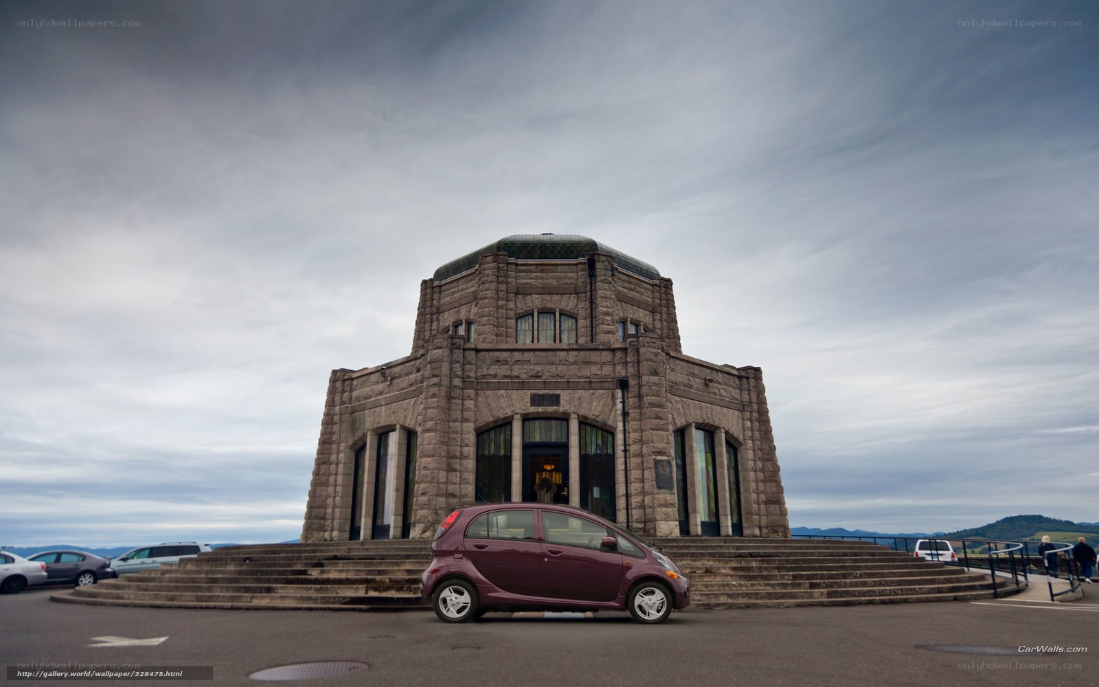 Maroon car in front of stone building