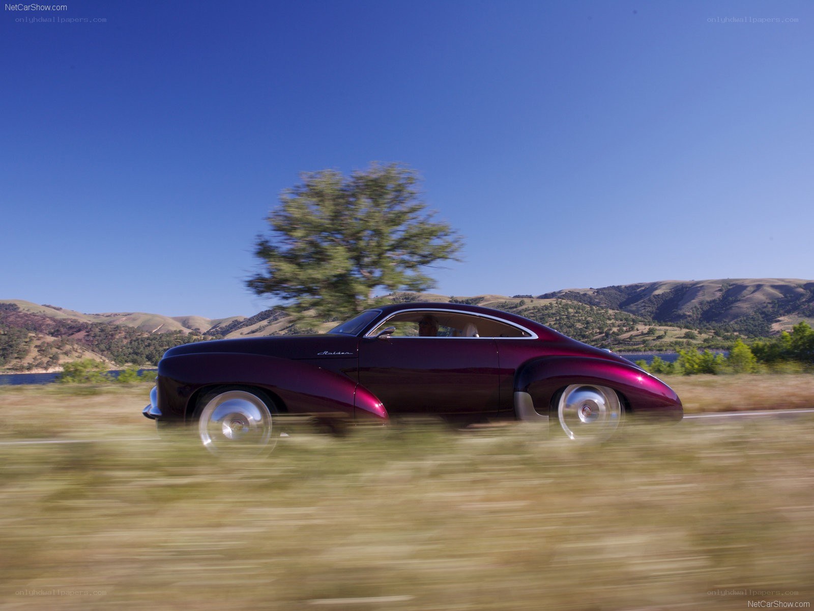 Maroon car on a scenic road