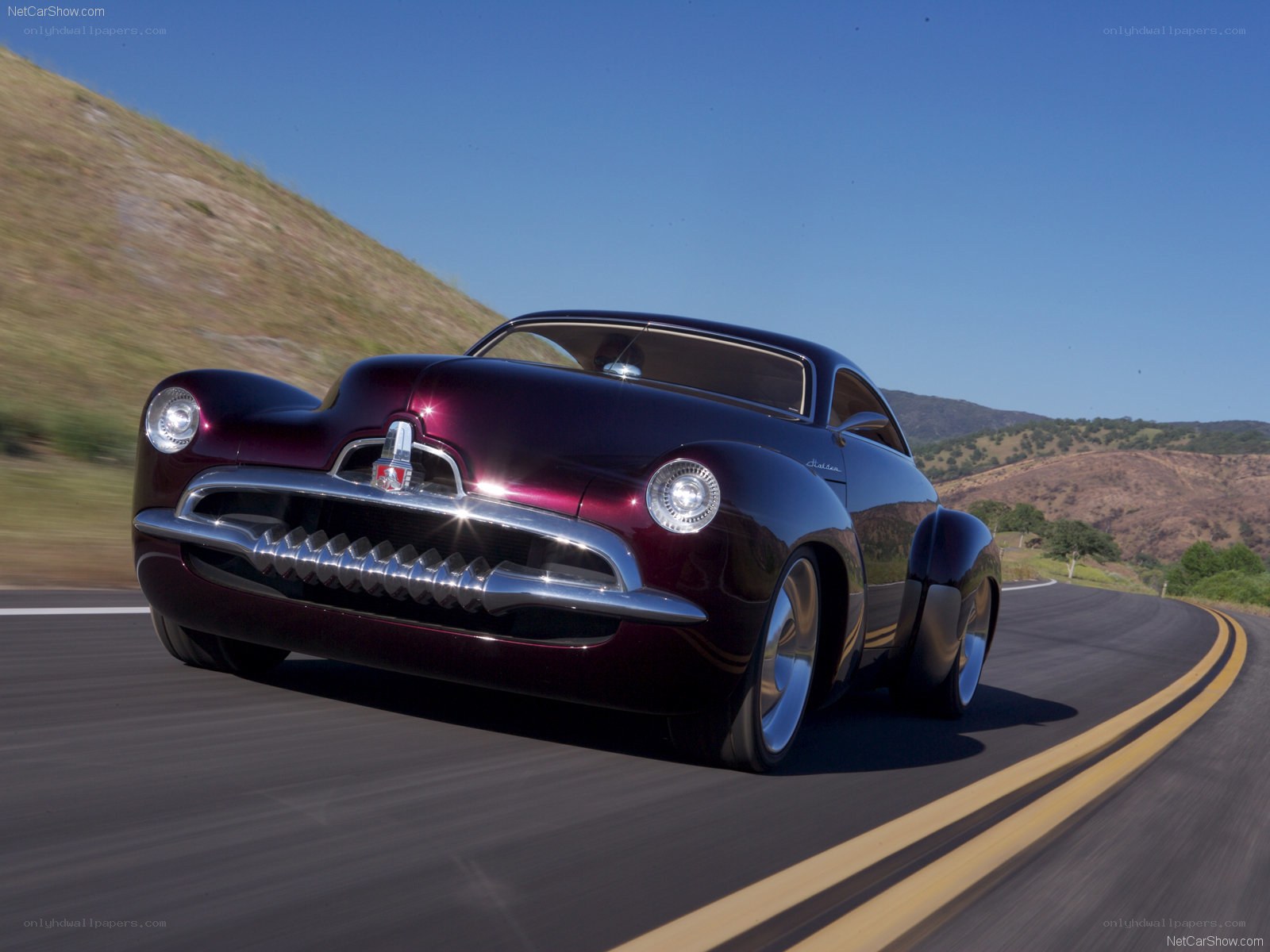 Maroon classic car on a winding road