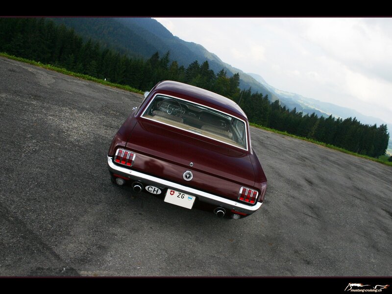 Maroon classic car on mountain road