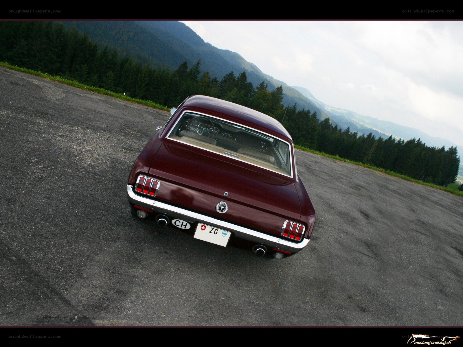 Maroon classic car on mountain road