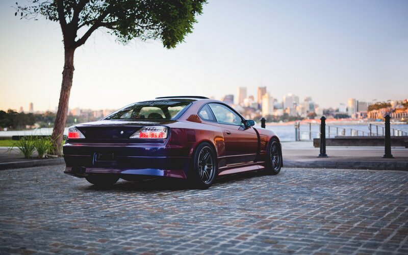 maroon coupe on cobblestones