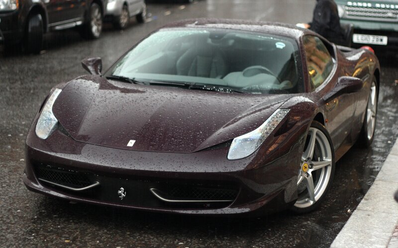 Maroon Ferrari on a rainy street