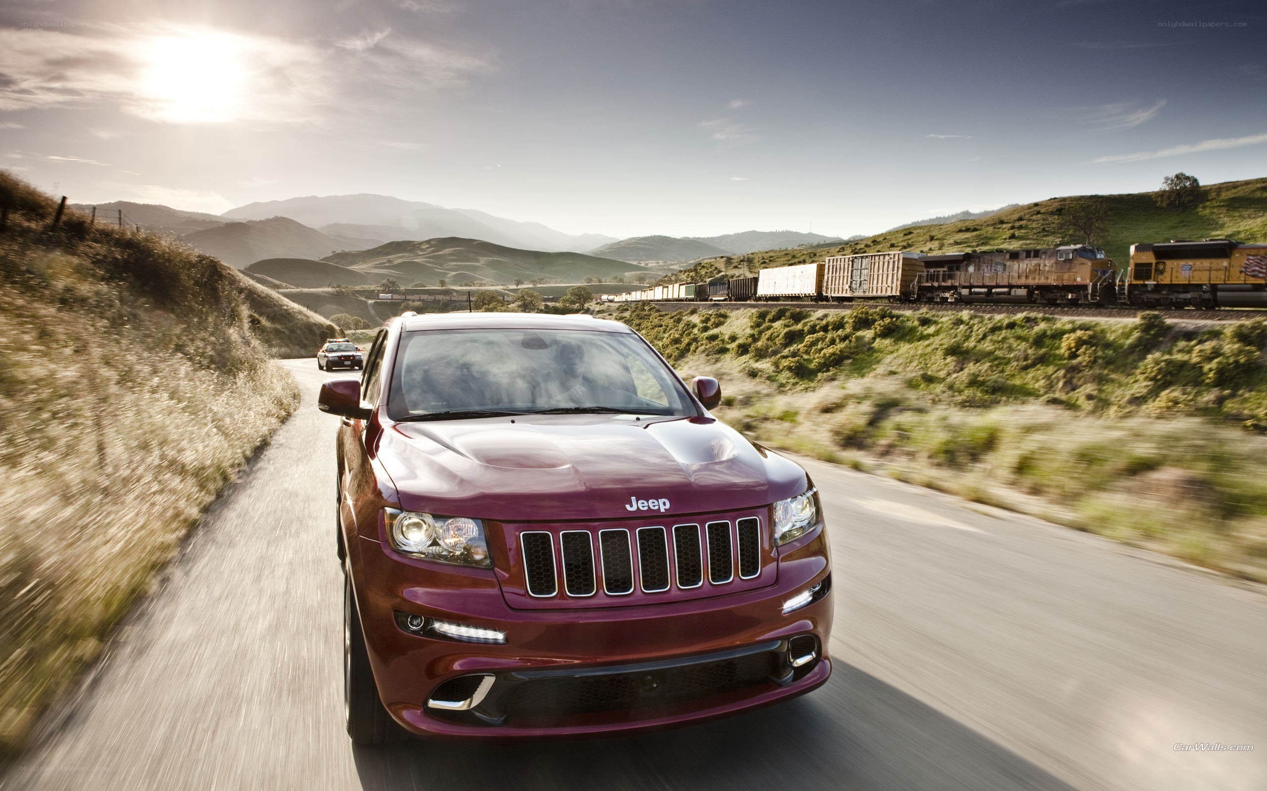 Maroon Jeep driving on a road