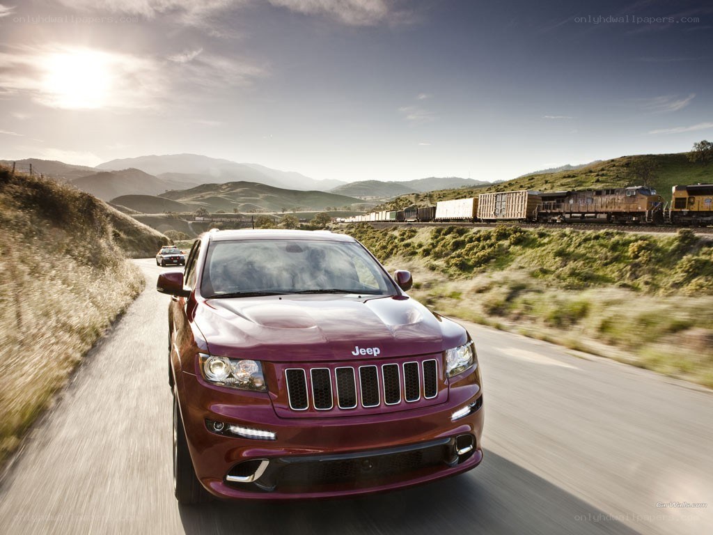 Maroon Jeep driving on a road