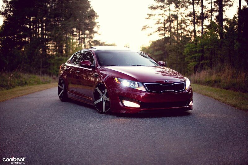 Maroon Kia Optima on a forest road