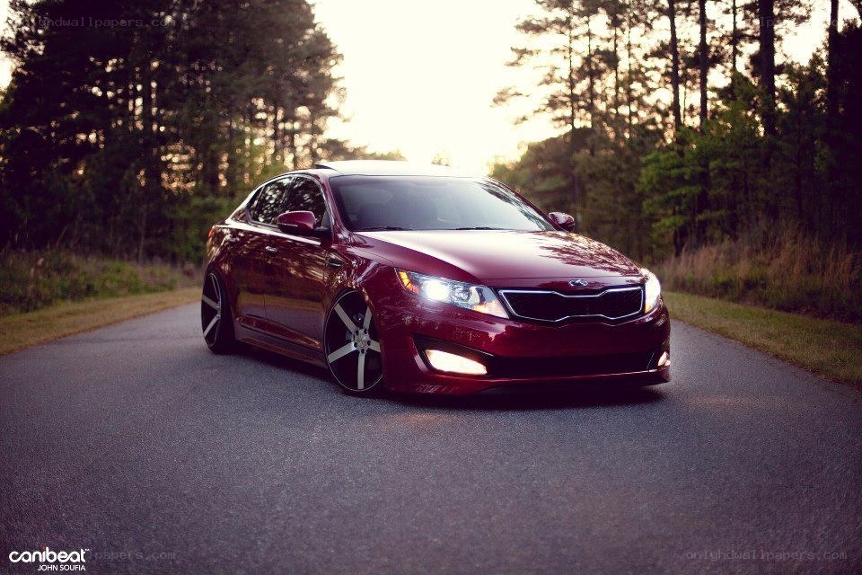 Maroon Kia Optima on a forest road