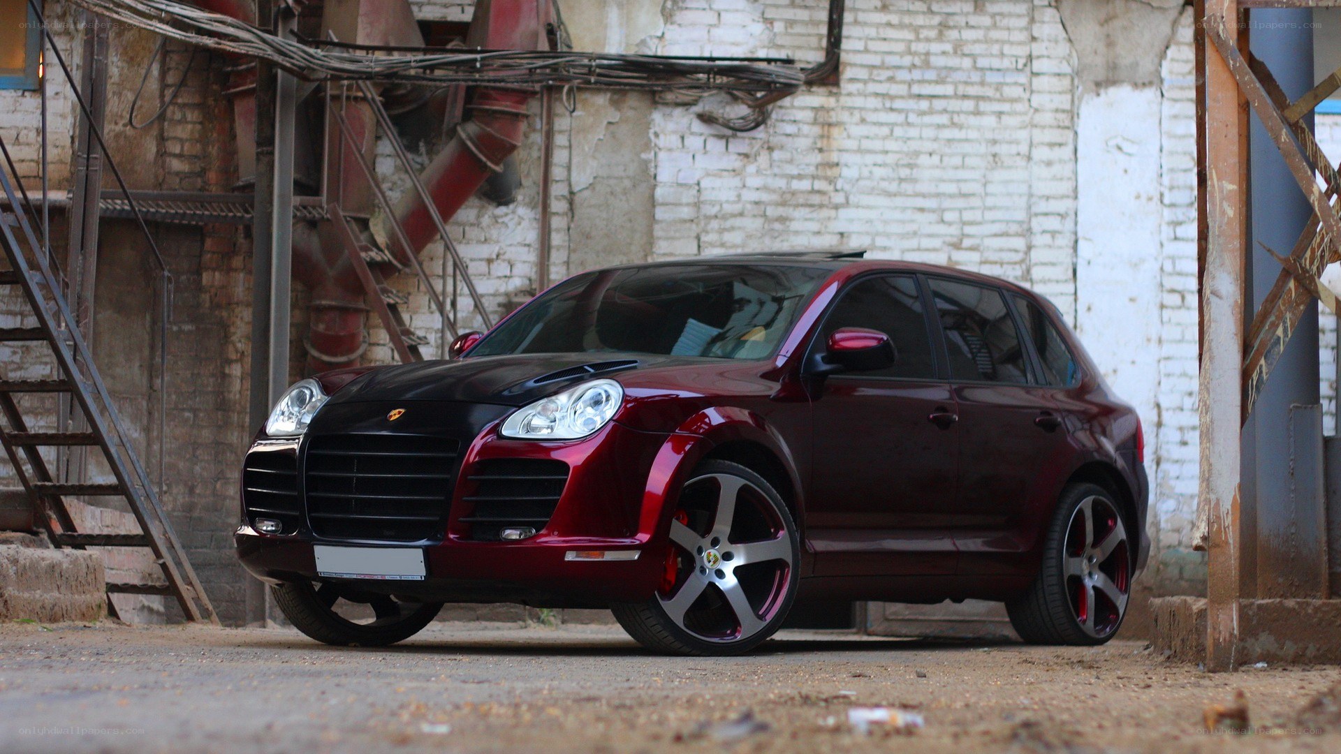 Maroon Porsche Cayenne in industrial setting