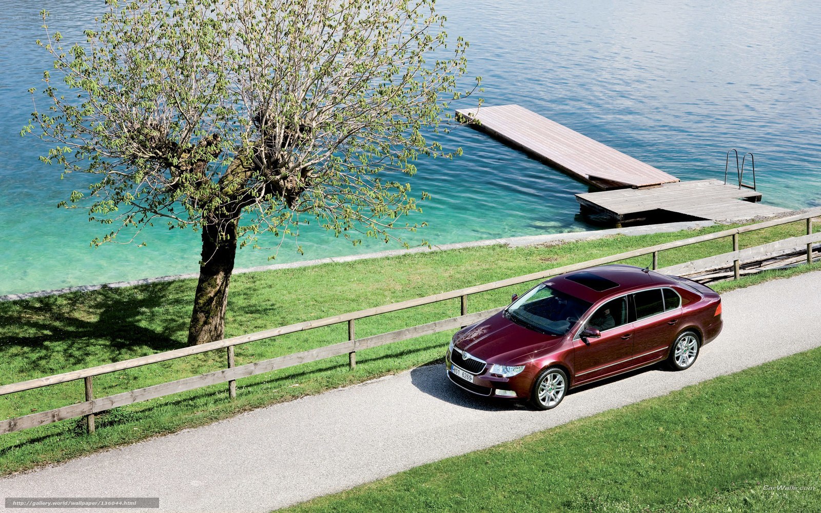 Maroon sedan by a lake