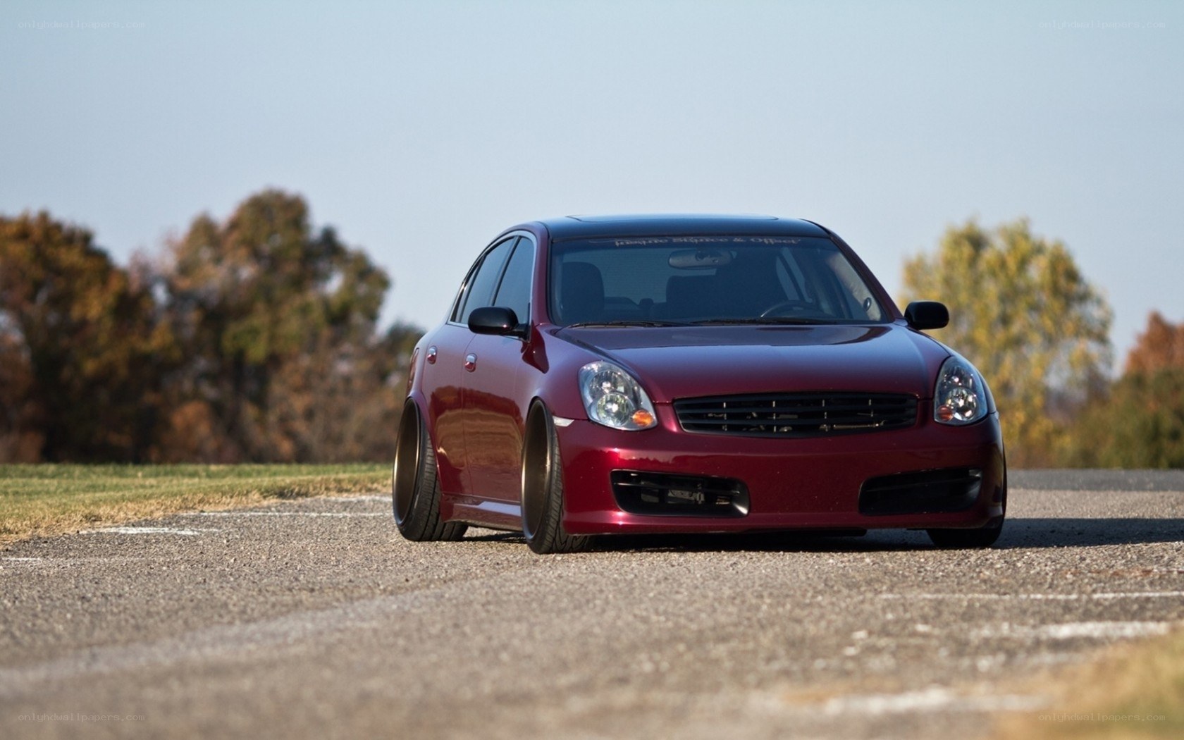 maroon sedan on asphalt