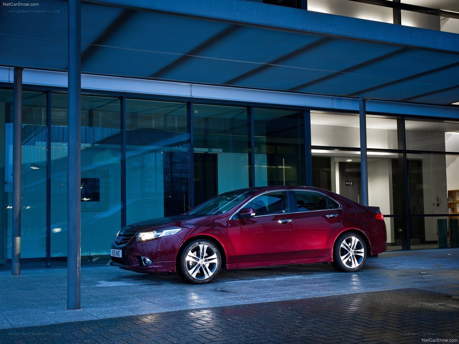 Maroon sedan parked outside modern building