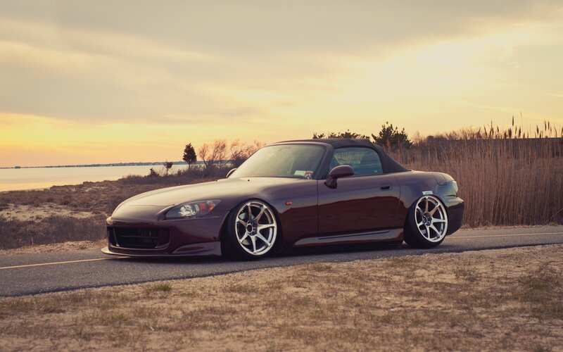 Maroon sports car at sunset