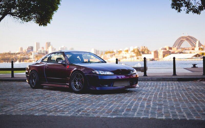 Maroon sports car by the harbor