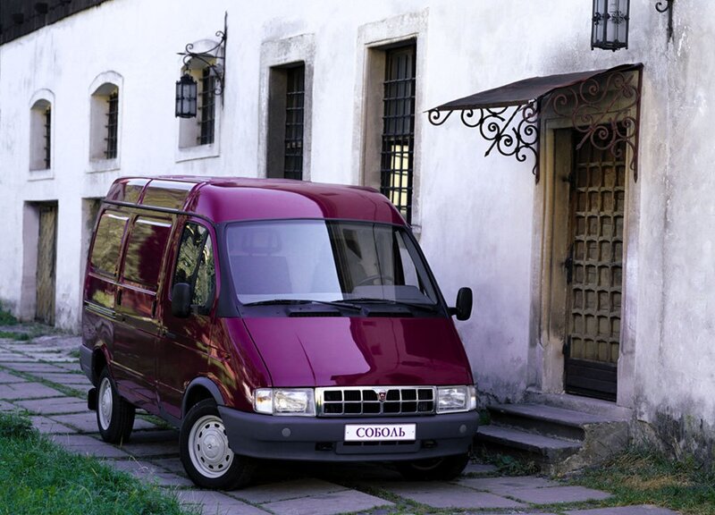 Maroon van parked by old building