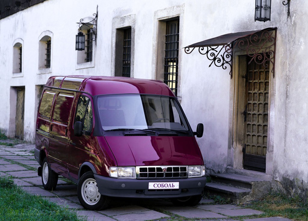Maroon van parked by old building