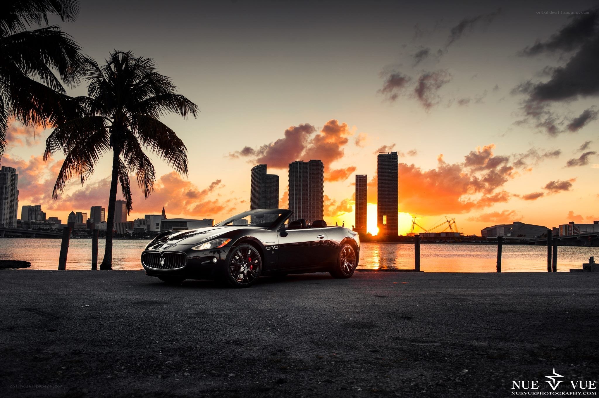Maserati on waterfront at sunset