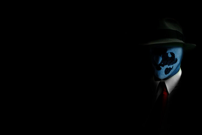 masked figure in dark suit