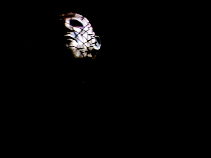 masked figure in darkness