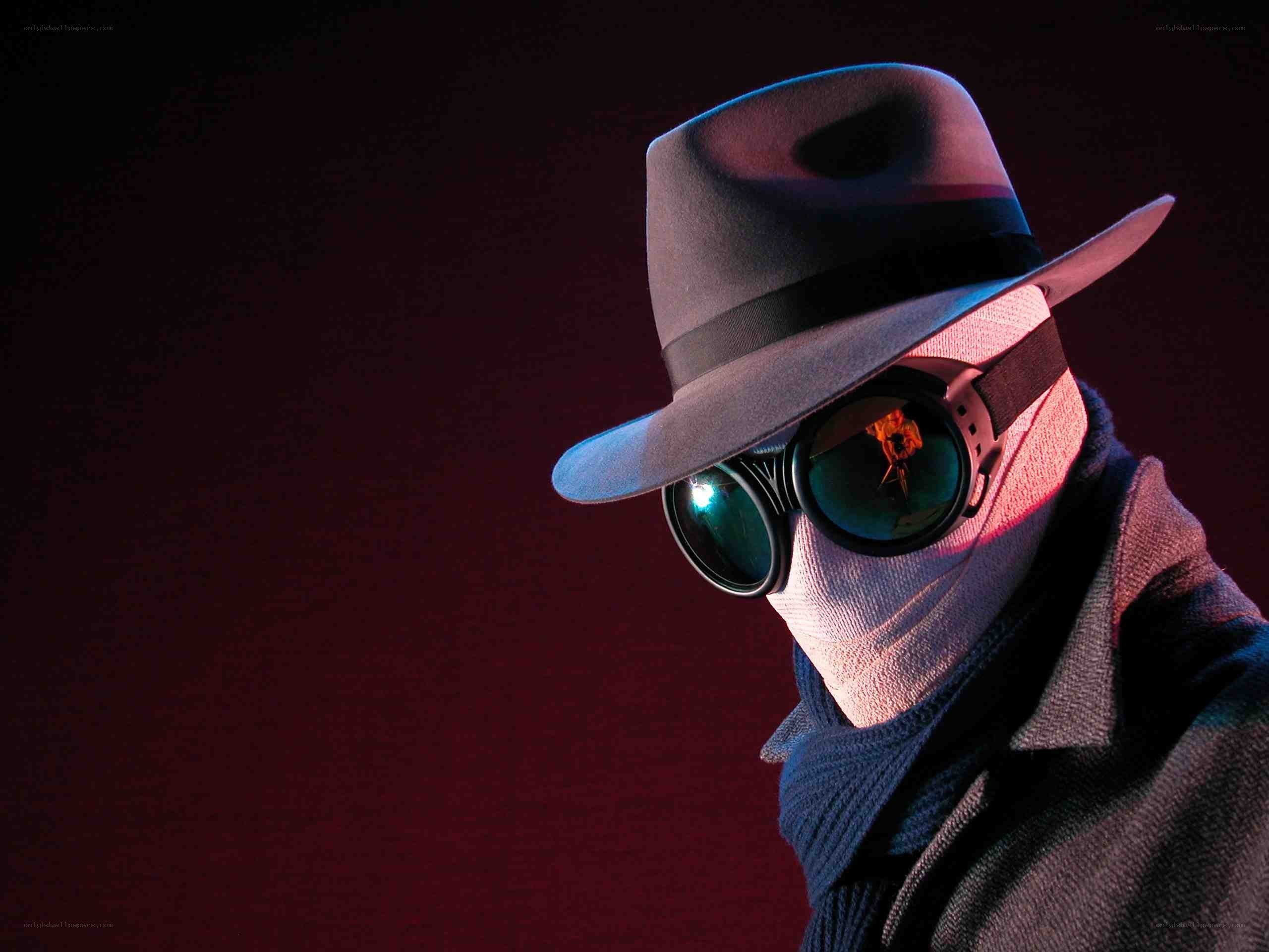 masked figure in fedora
