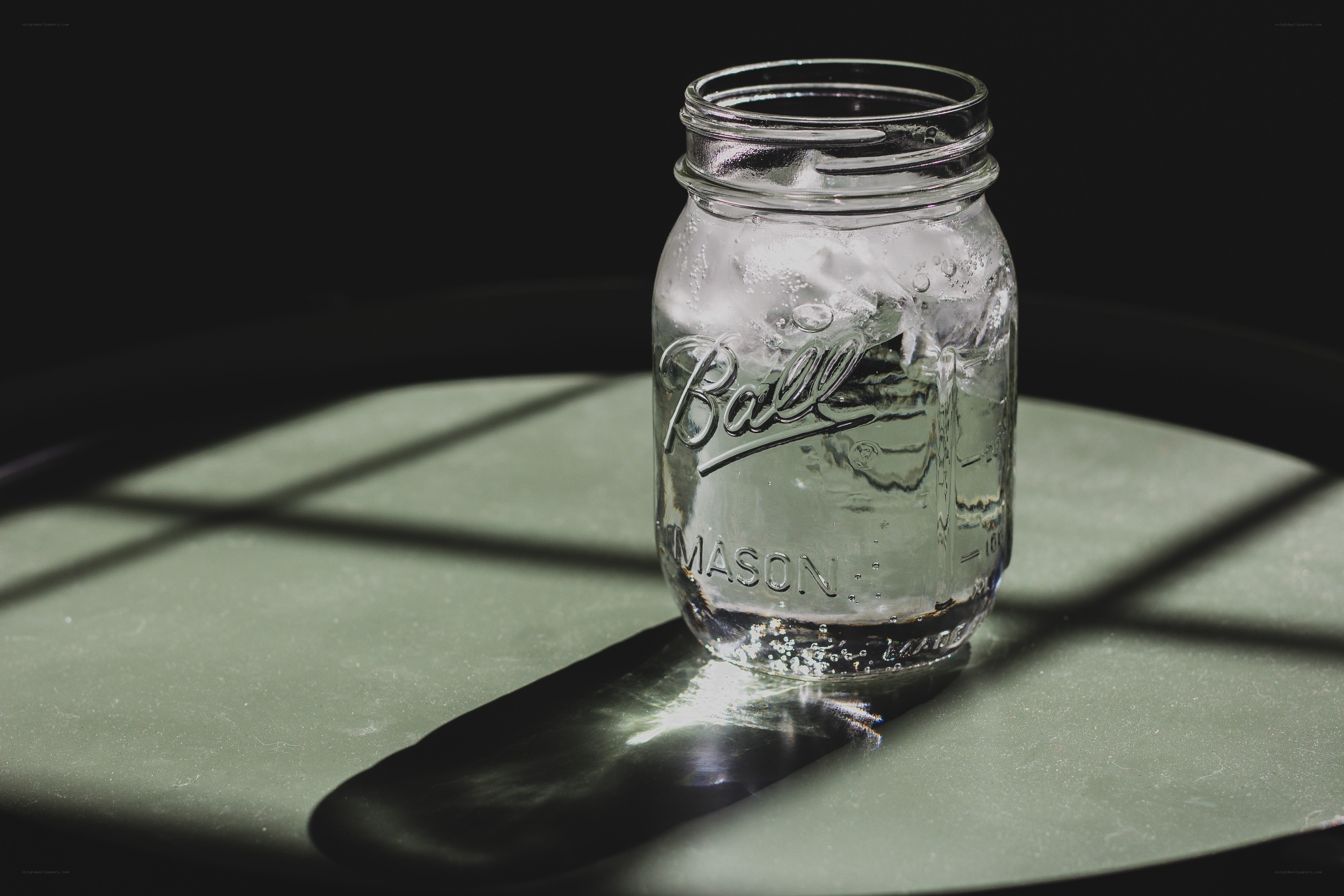 Mason jar with ice on table