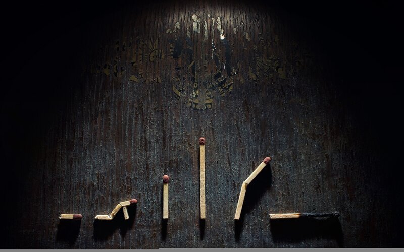 Matchstick figures on dark wood