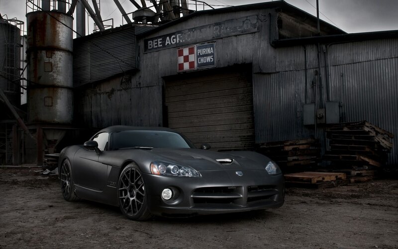 Matte black sports car in industrial setting