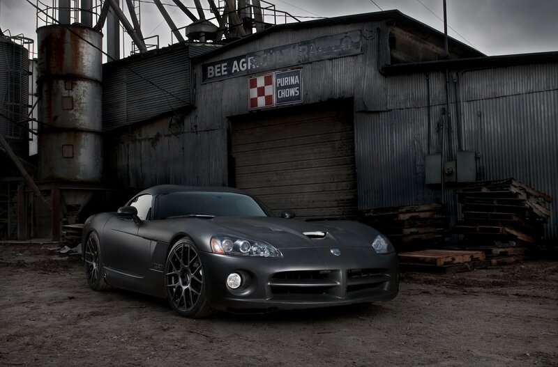 Matte black sports car in industrial setting
