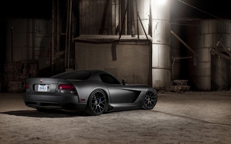 Matte black sports car in warehouse