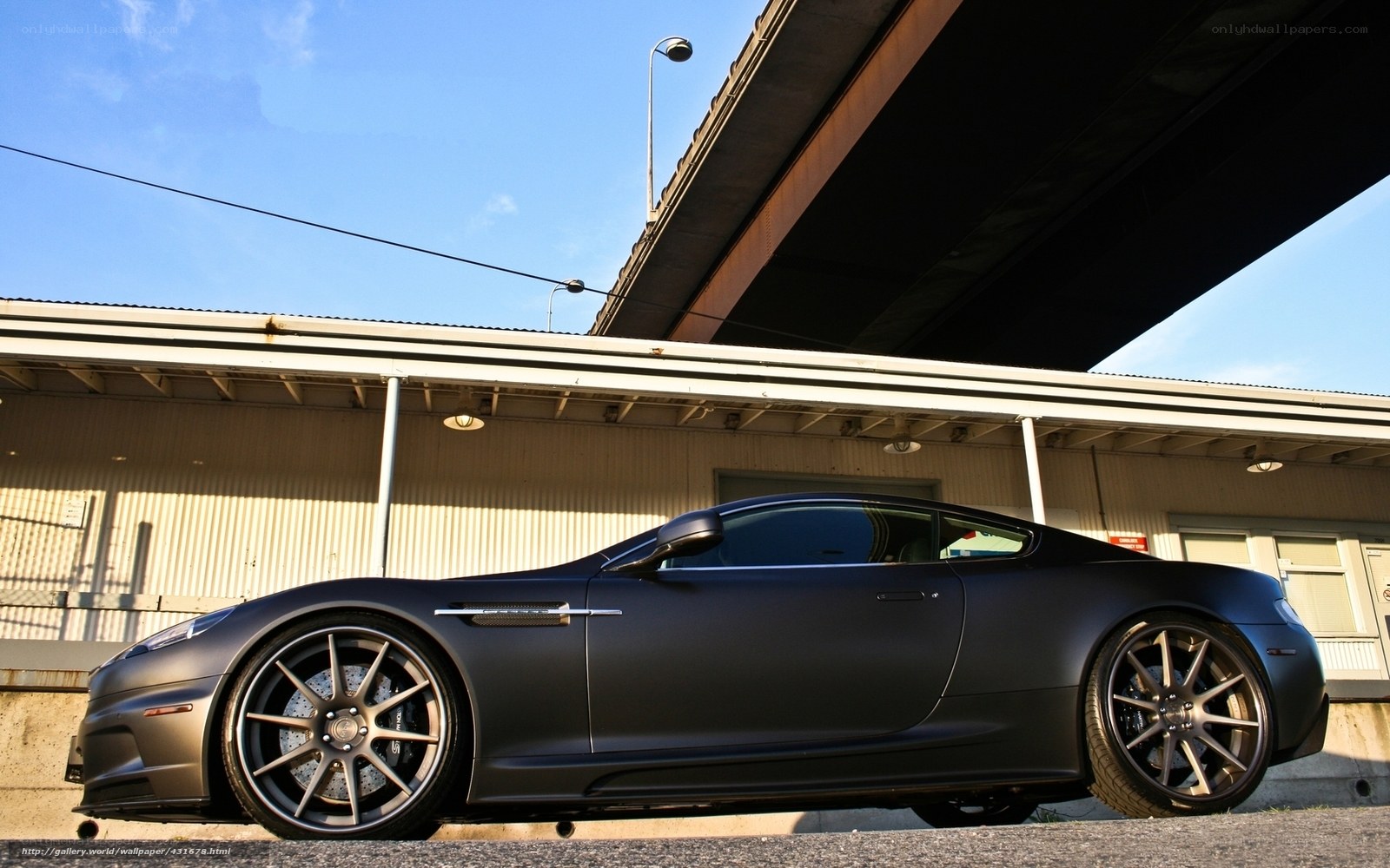 Matte black sports car under bridge