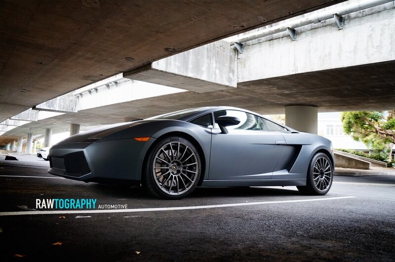 Matte gray Lamborghini under overpass