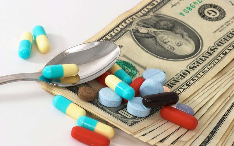 Medications and money on a dollar bill