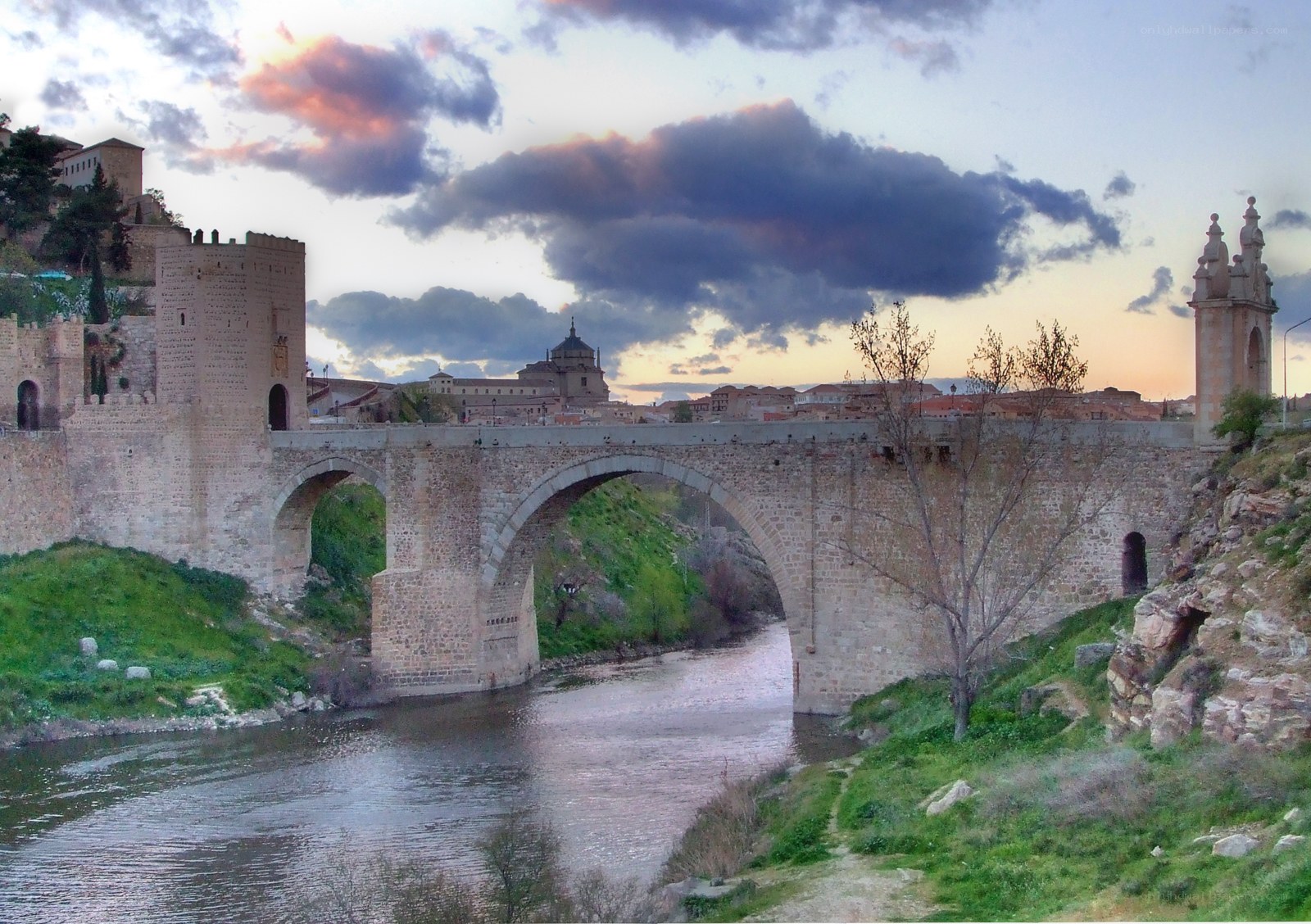 Medieval bridge over river at sunset