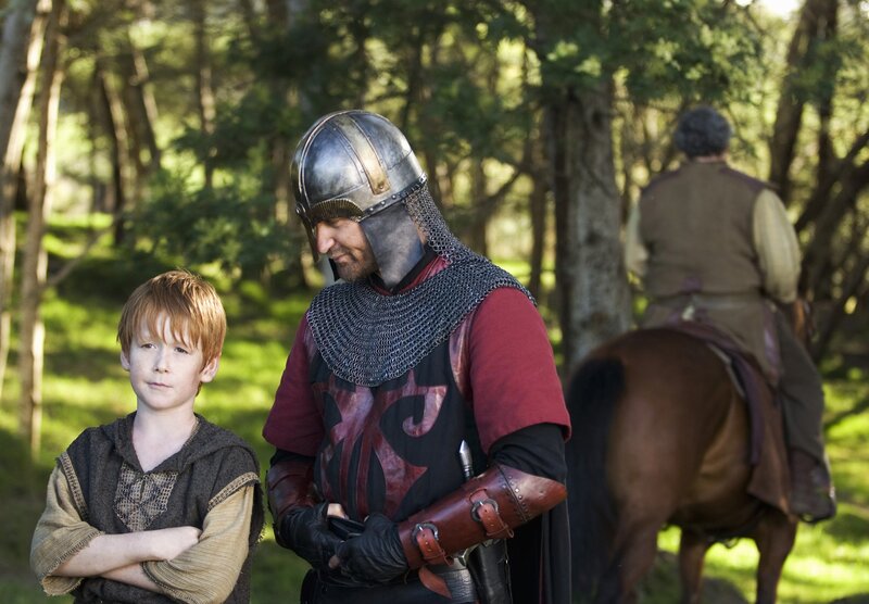 Medieval knight with boy in forest