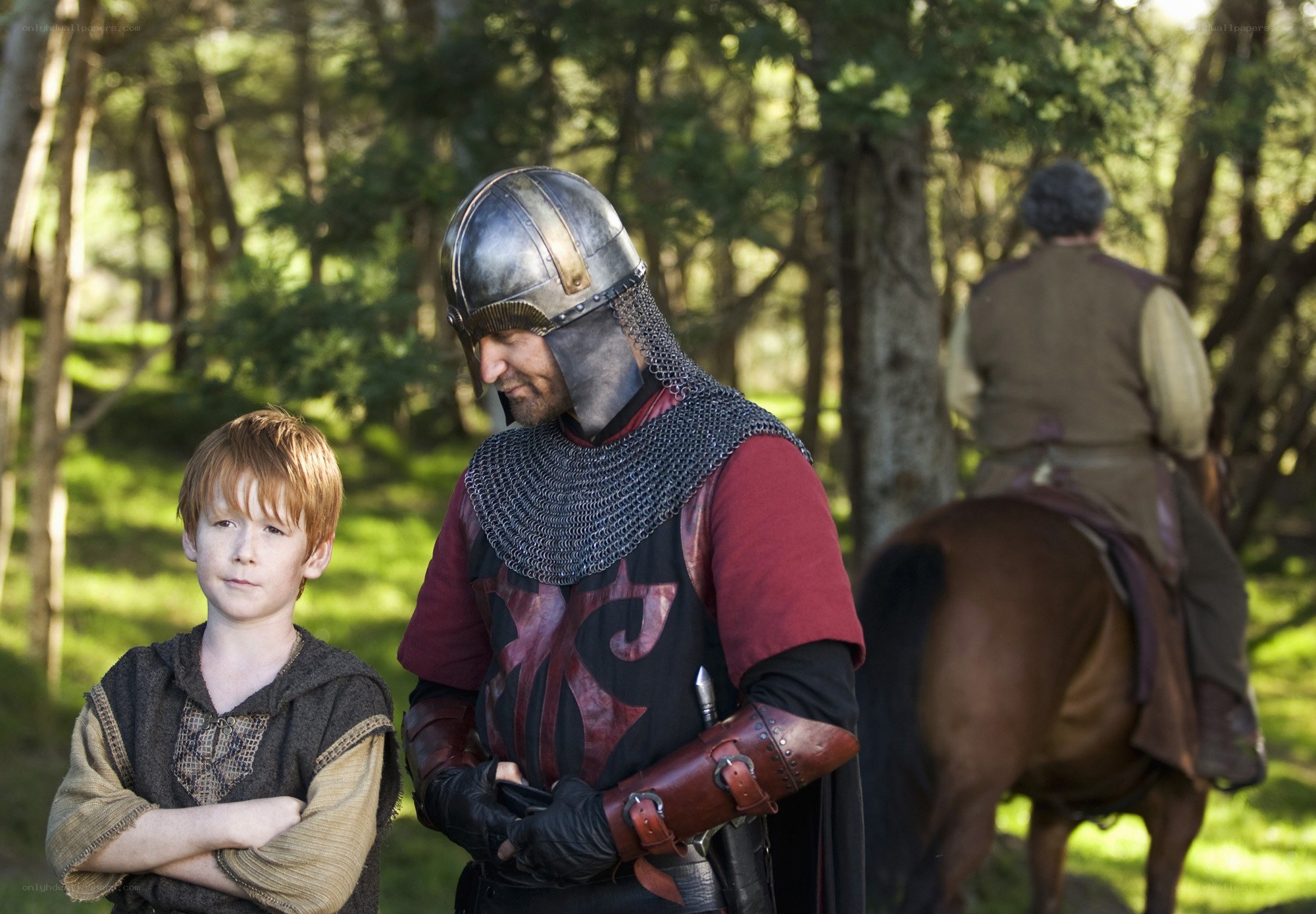 Medieval knight with boy in forest