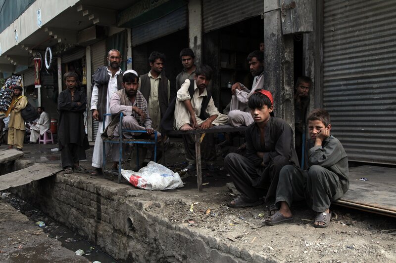 Men and boys waiting on a street