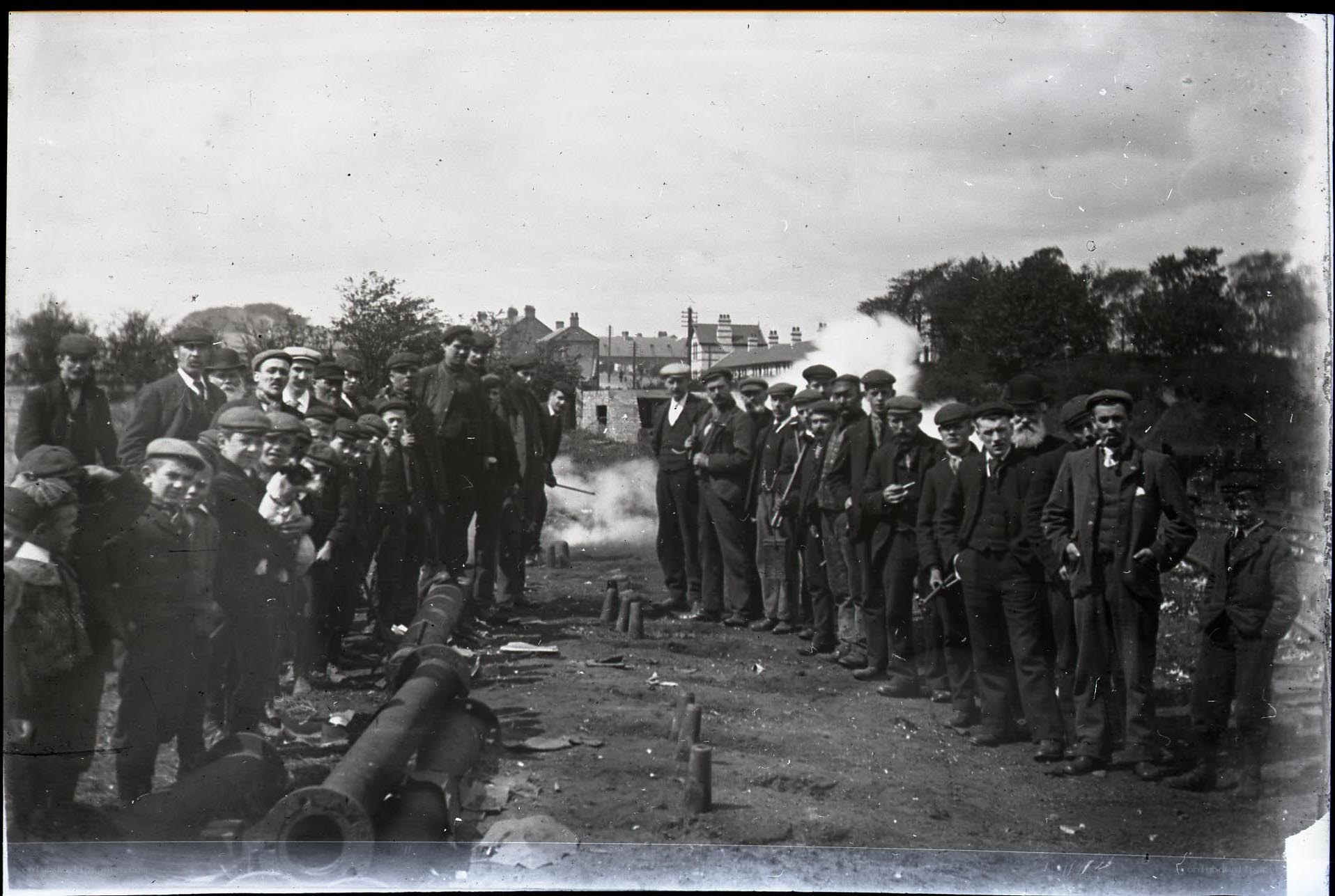 Men and boys watching cannon fire