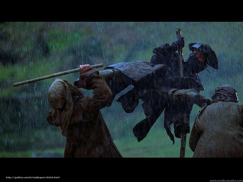 Men carrying a body in rain