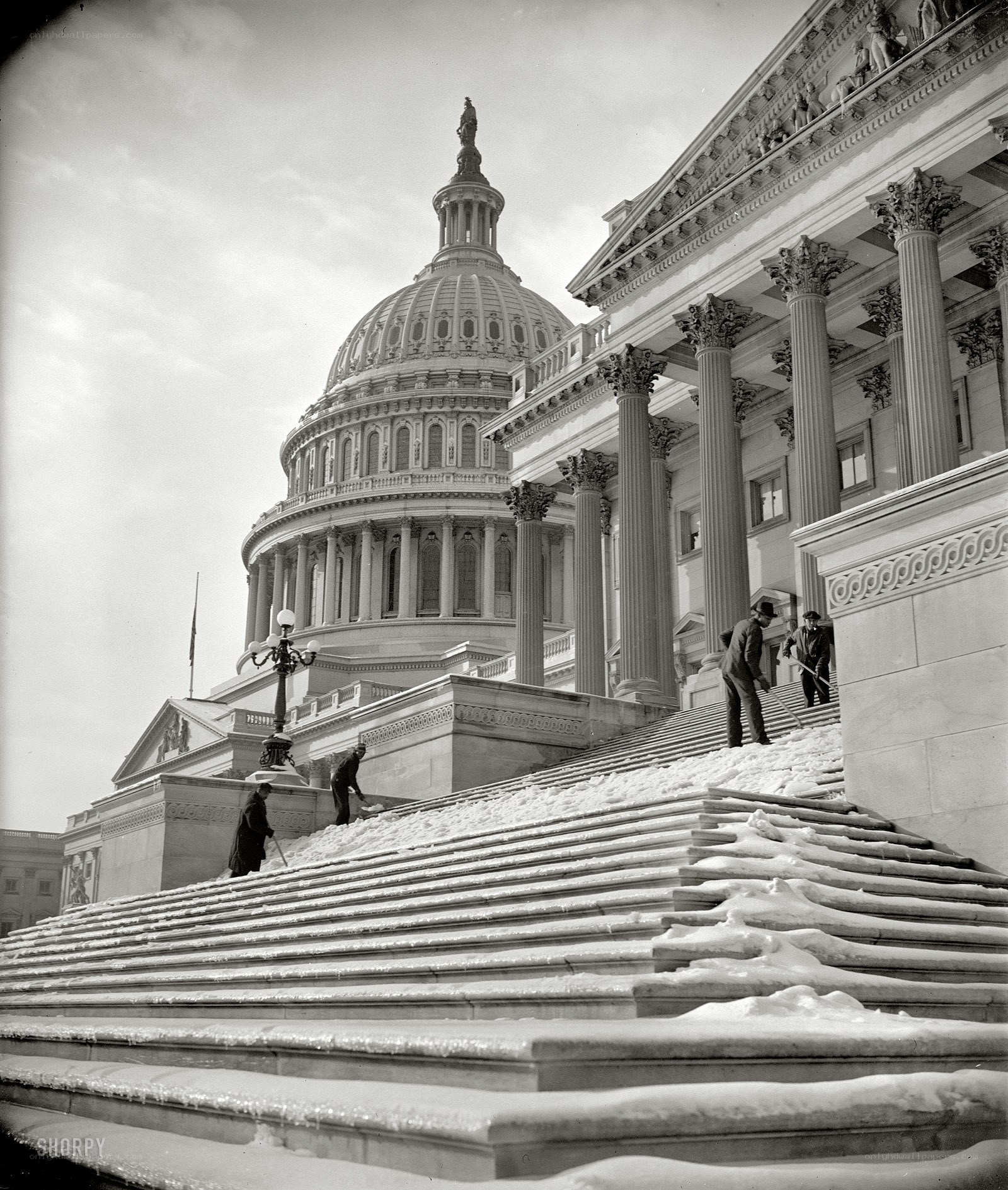 Men clearing snow from Capitol steps