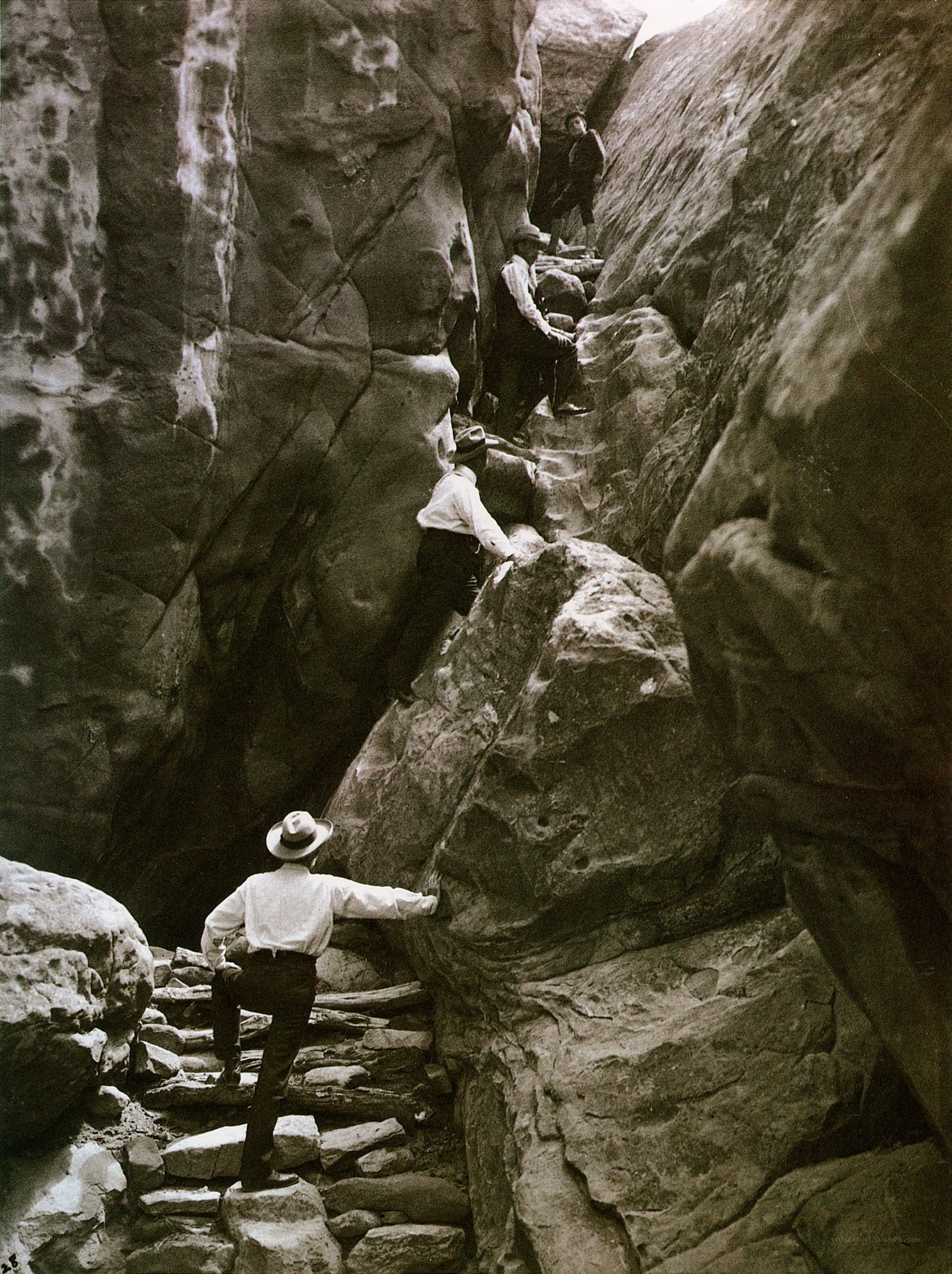 Men climbing rocky canyon