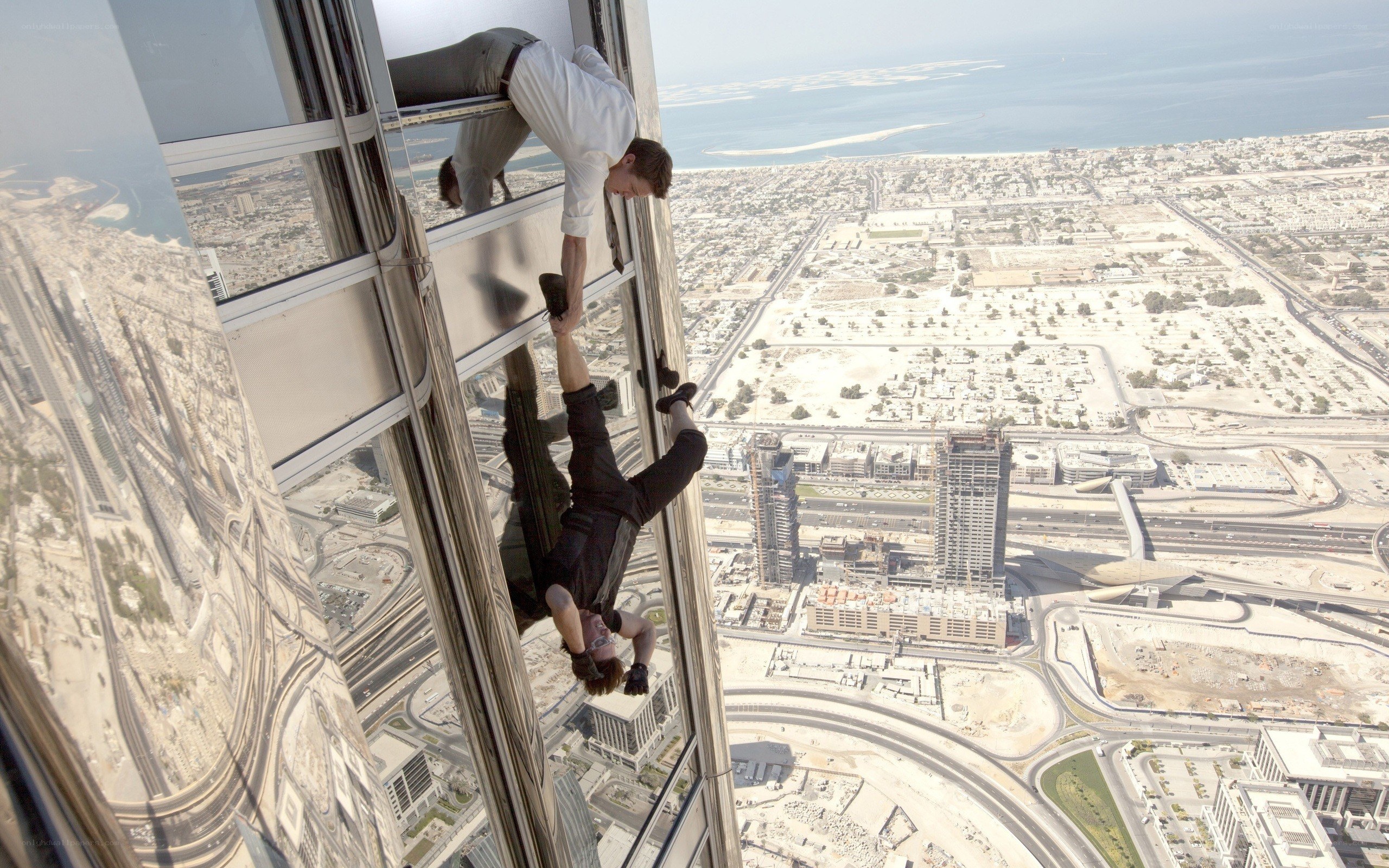 Men climbing skyscraper exterior