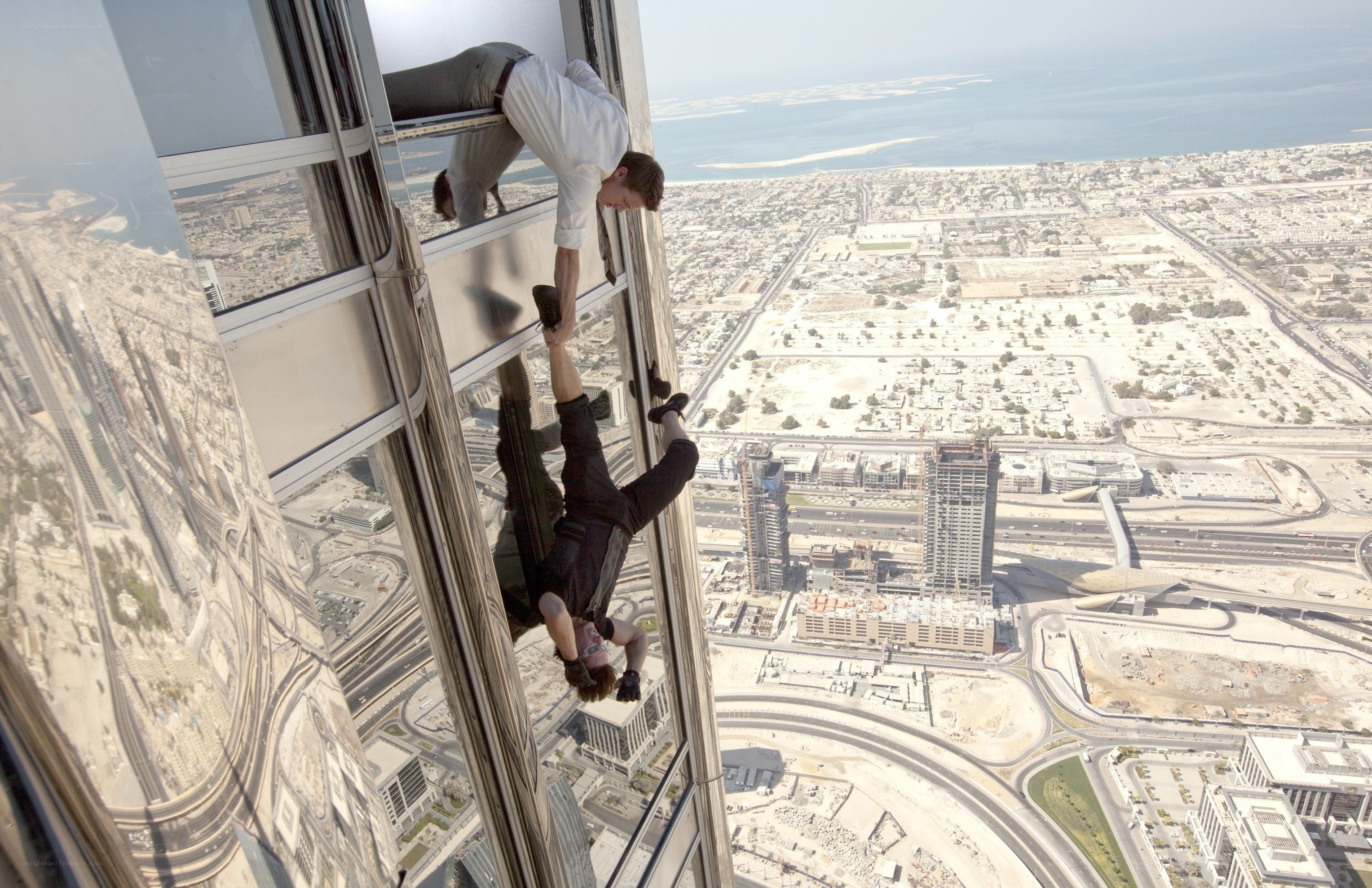 Men climbing skyscraper exterior