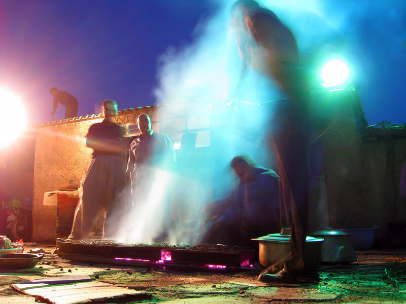 Men cooking on a rooftop at night