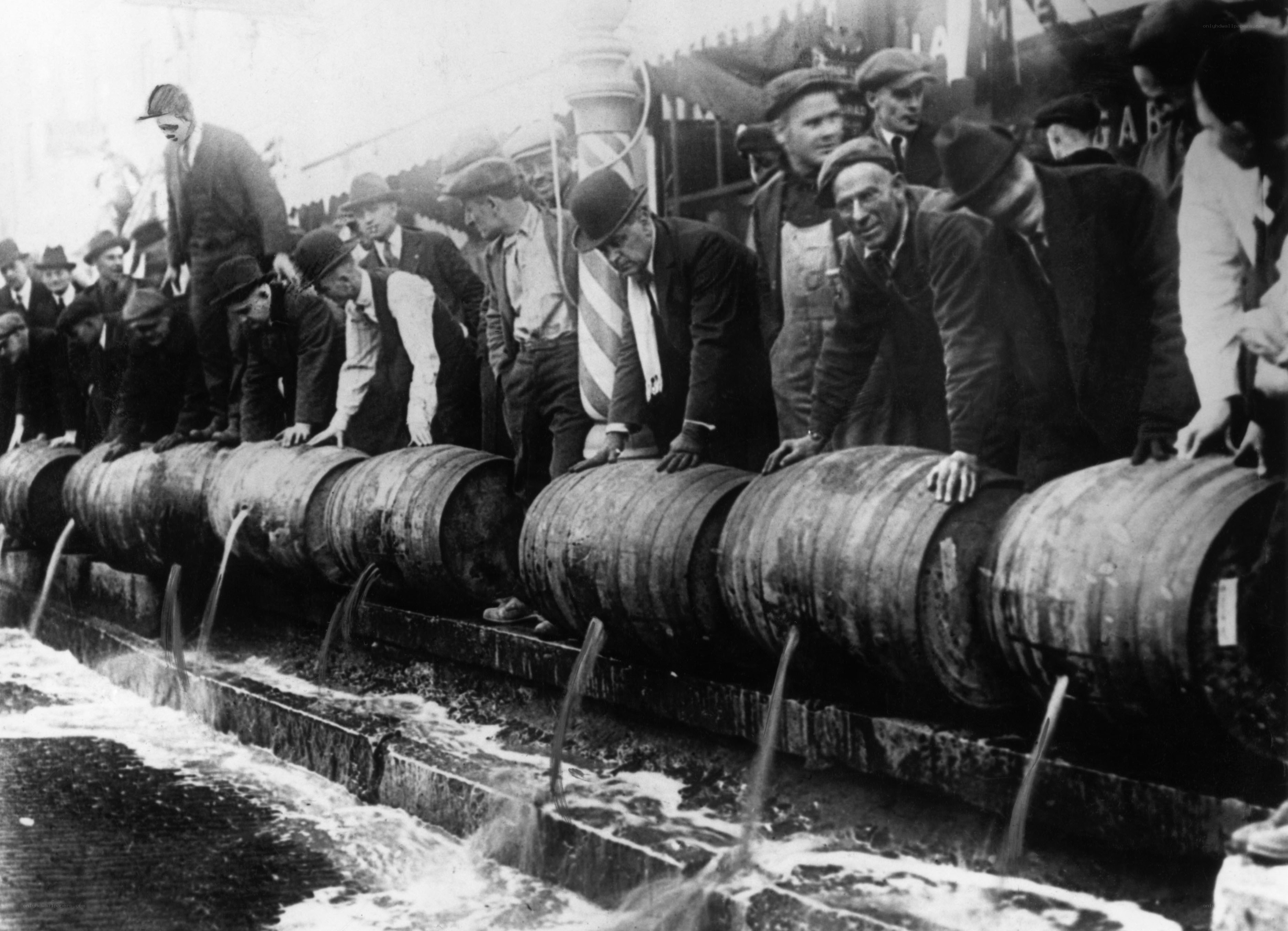 Men drinking from barrels