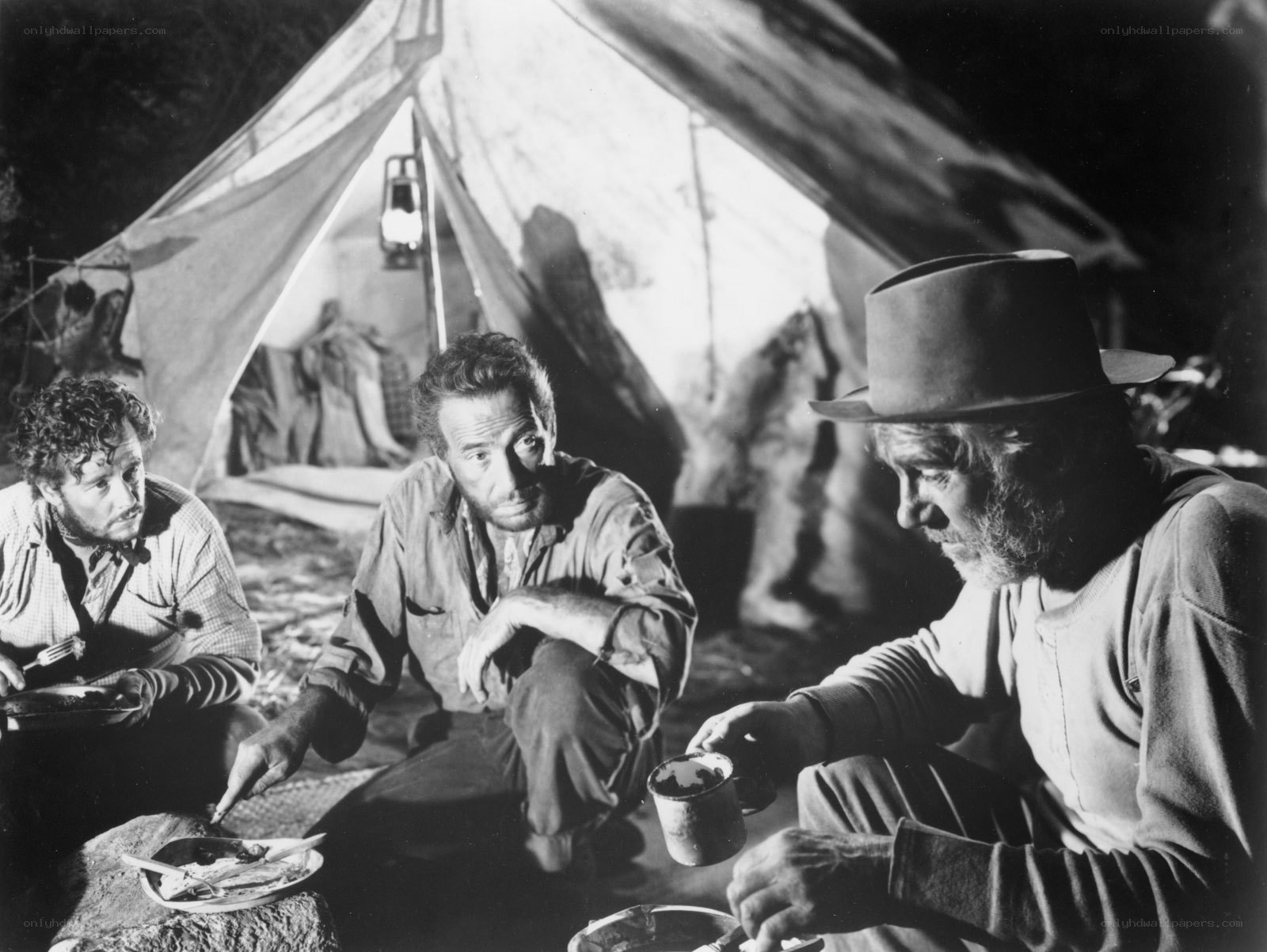 Men eating by tent at night