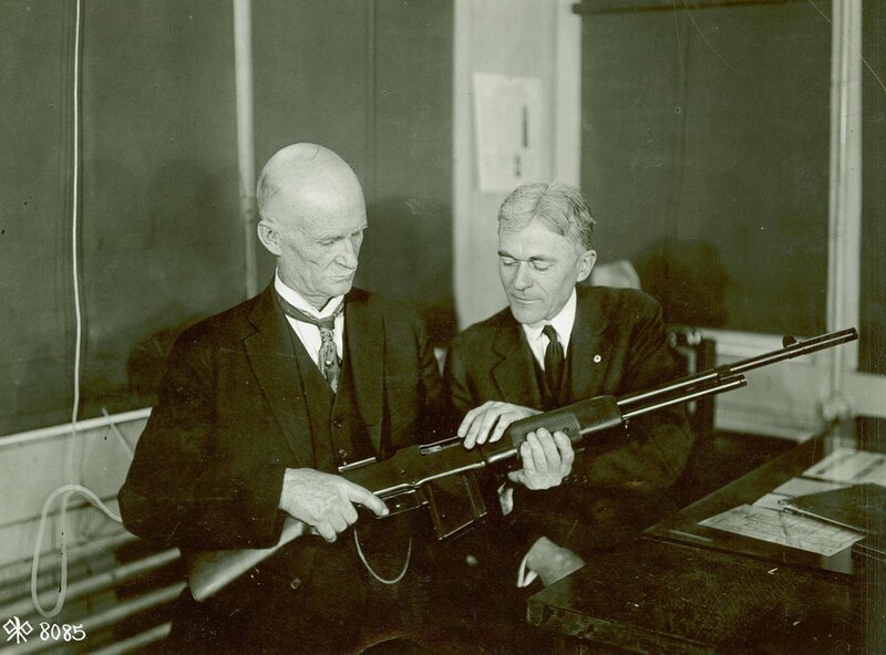 Men examining a rifle