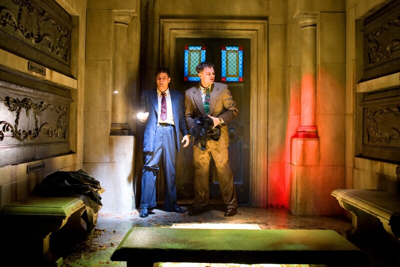 Men in a crypt with flashlights